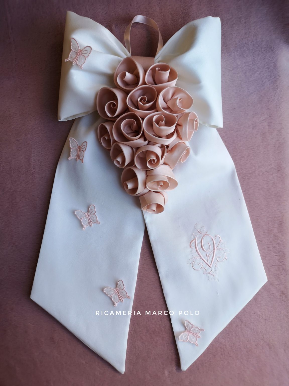 Cascata di rose cipria su fiocco in pura seta bianca